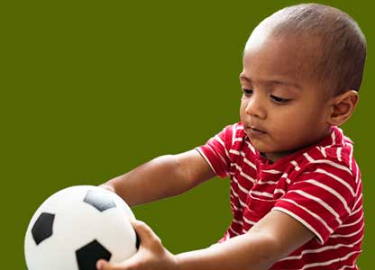 very young boy playing with a ball